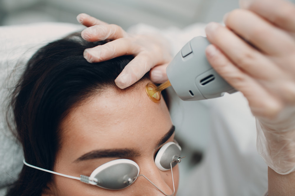 Especialista aplicando GlowUp Facial con láser en rostro de clienta con protección ocular